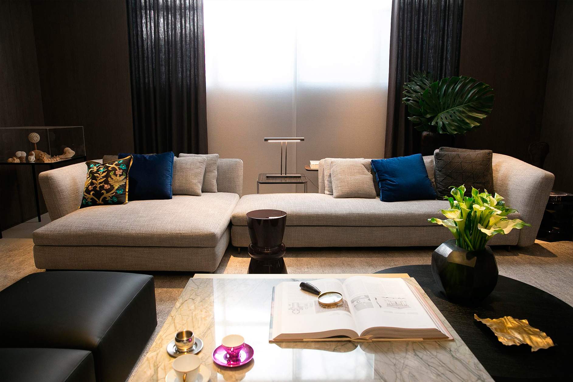 sala de estar com sofá cinza e livro grande na casa cor