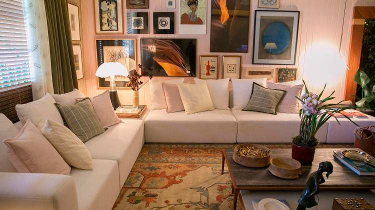 sala de estar com tapete grande, quadros e sofá branco na casa cor 2016