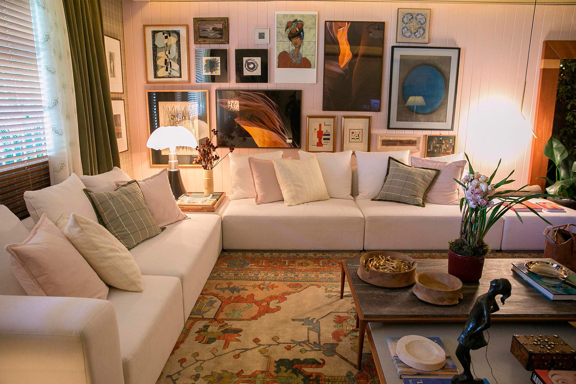 sala de estar com tapete grande, quadros e sofá branco na casa cor 2016