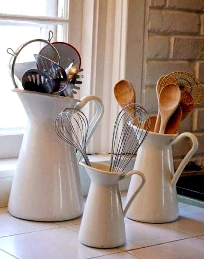 Quem já pensou em usar jarras como organizadores? Colheres de pau, coadores, fuês, espátulas e outros utensílios podem ser distribuídos em jarras de diferentes tamanhos. Ideia de organização bonita e fácil de ser colocada em prática! (Foto: Reprodução)