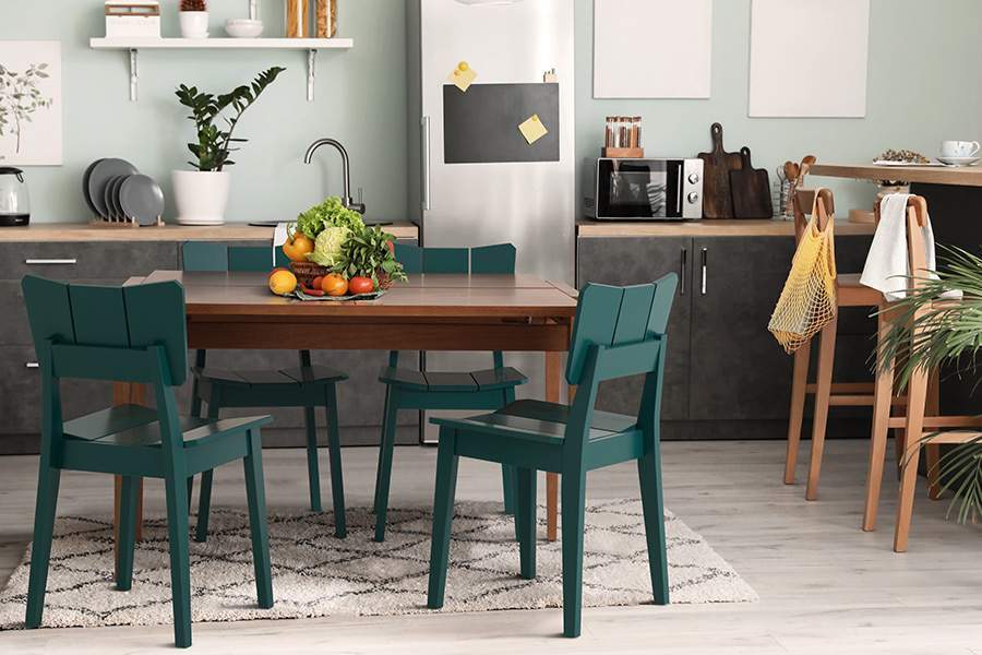 Cozinha com Mesa de Madeira e Cadeiras Uma verde.
